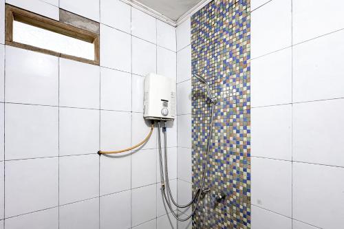 a shower in a bathroom with a tile wall at RedDoorz at Argapuri Resort Gambung in Gambung