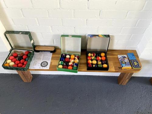 three boxes of apples sitting on a wooden bench at Hunter Valley Homes Pets Heated Pool in Whittingham
