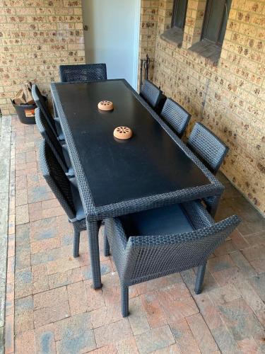 a black table and chairs with two cookies on it at Hunter Valley Homes Pets Heated Pool in Whittingham