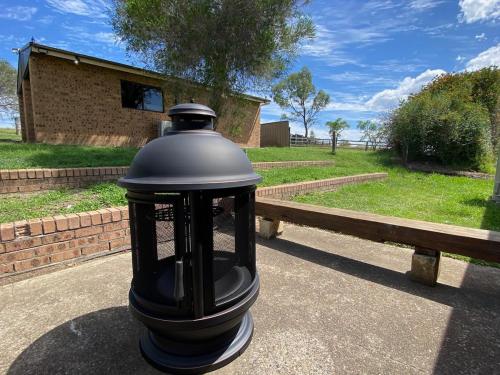 a black lantern sitting next to a bench at Hunter Valley Homes Pets Heated Pool in Whittingham