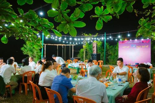 a group of people sitting at tables at an event at Seasand Quảng Bình - by BAY LUXURY in Dong Hoi
