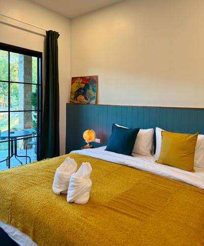 a bedroom with a large bed with two pillows on it at แคมป์คาฟ จันทบุรี ( Kamp Kaff) in Ban Khlong Som (1)