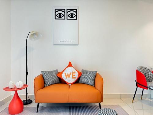 an orange couch with a pillow on it in a room at The Ruby - Subang Jaya Edumetro SEGi College in Subang Jaya