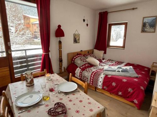 - une chambre avec un lit et une table avec des plaques de cuisson dans l'établissement Appartement cosy 4 pers avec balcon à Val Cenis - FR-1-508-307, à Val Cenis