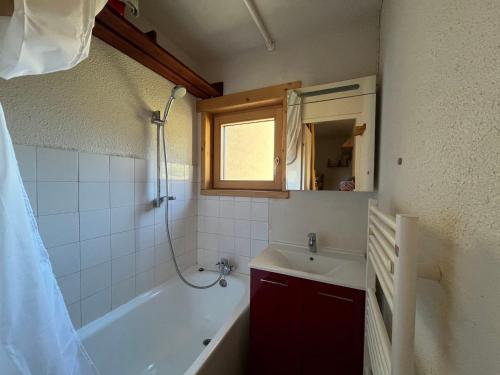 une salle de bain avec une baignoire, un lavabo et un miroir dans l'établissement Appartement cosy 4 pers avec balcon à Val Cenis - FR-1-508-307, à Val Cenis