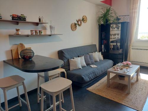 un salon avec un canapé bleu et une table dans l'établissement Appartement lumineux rénové, près de Nancy - FR-1-584-372, à Sexey-les Bois