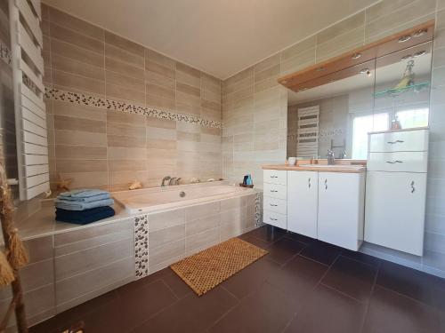 une salle de bain avec une baignoire et un lavabo dans l'établissement Appartement lumineux rénové, près de Nancy - FR-1-584-372, à Sexey-les Bois