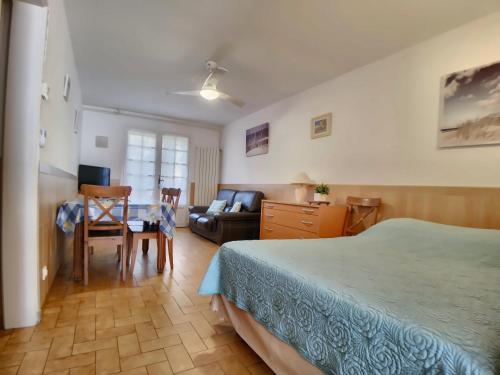 une chambre avec un lit, une table et un canapé dans l'établissement Appartement 6 pers, jardinet privatif, WiFi - FR-1-475-145, à Saintes-Maries-de-la-Mer