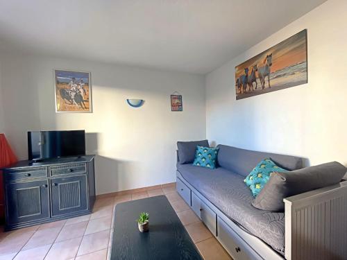 un salon avec un canapé et une télévision à écran plat dans l'établissement Appartement 4 pers aux Saintes-Maries-de-la-Mer avec Cour et Parking - FR-1-475-150, à Saintes-Maries-de-la-Mer