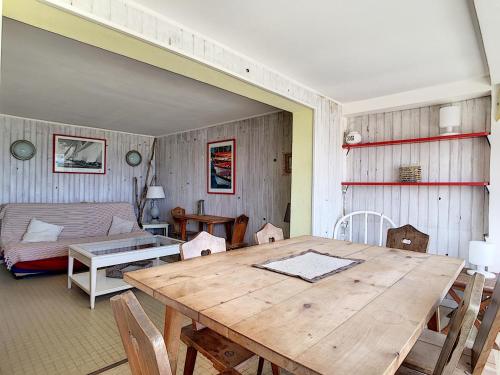 - une salle à manger avec une table en bois et un canapé dans l'établissement Appartement T4 en bord de plage avec terrasse et parking à Carnon - FR-1-715-103, à Mauguio