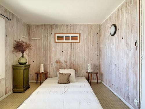 une chambre avec un lit blanc et des murs en bois dans l'établissement Appartement T4 en bord de plage avec terrasse et parking à Carnon - FR-1-715-103, à Mauguio