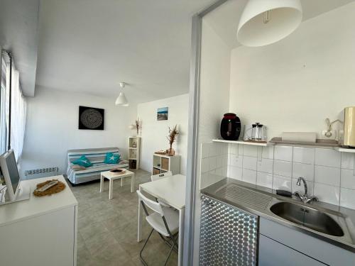 une cuisine avec un évier et un salon dans l'établissement Studio avec Balcon et Parking à 2 Pas de la Plage - FR-1-652-56, à Saint-Hilaire-de-Riez
