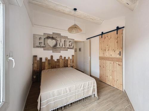 - une chambre avec un lit et une porte en bois dans l'établissement Appartement pour 4, rénové, climatisé, aux Saintes-Maries-de-la-Mer - FR-1-475-152, à Saintes-Maries-de-la-Mer