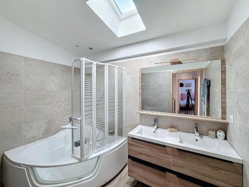 une salle de bain avec une baignoire, un lavabo et un miroir dans l'établissement Maison mitoyenne climatisée pour 6 pers. à Saintes-Maries-de-la-Mer - FR-1-475-149, à Saintes-Maries-de-la-Mer