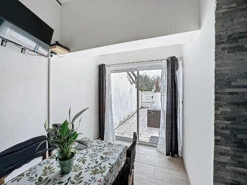d'une salle à manger avec une table et une plante. dans l'établissement Appartement 4 pers. Climatisation, Animaux admis - FR-1-475-153, à Saintes-Maries-de-la-Mer