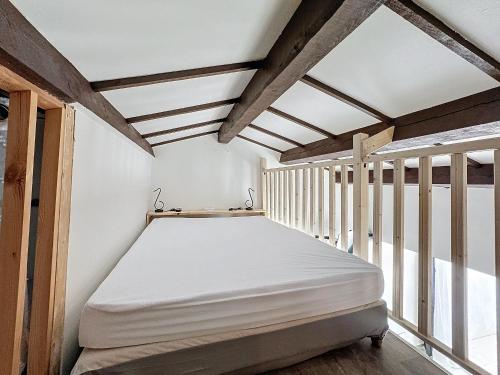 Ce lit se trouve dans un dortoir doté de poutres apparentes. dans l'établissement Appartement 4 pers. Climatisation, Animaux admis - FR-1-475-153, à Saintes-Maries-de-la-Mer