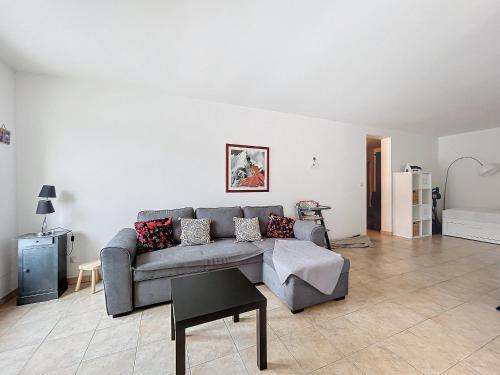 un salon avec un canapé gris et une table dans l'établissement Appartement calme 110m² aux Saintes-Maries-de-la-Mer - FR-1-475-156, à Saintes-Maries-de-la-Mer
