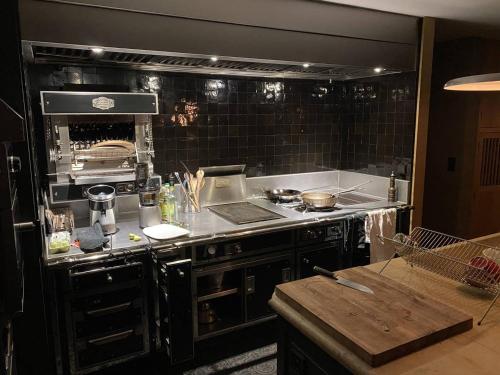 eine Küche mit einem Herdofen in einer Küche in der Unterkunft Domaine de Coursat avec piscine chauffée et services haut de gamme pour 16 personnes - FR-1-791-35 in Castets