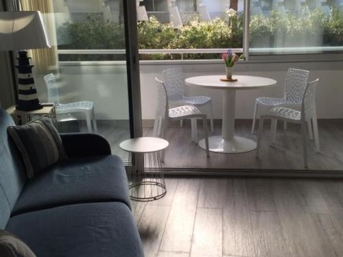 un salon avec un canapé, une table et des chaises dans l'établissement Appartement 2 pièces cabine climatisé pour 4 personnes au Grau du Roi avec parking - FR-1-731-128, au Grau-du-Roi