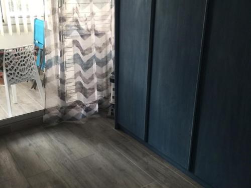 Cette chambre dispose de murs bleus, d'une table et d'une fenêtre. dans l'établissement Appartement 2 pièces cabine climatisé pour 4 personnes au Grau du Roi avec parking - FR-1-731-128, au Grau-du-Roi