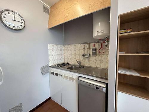 une cuisine avec un évier et une horloge murale dans l'établissement Studio confortable face mer avec garage privé, Saint-Hilaire-de-Riez - FR-1-224C-336, à Saint-Hilaire-de-Riez