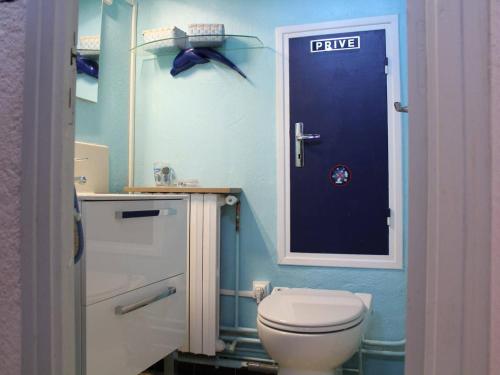 La salle de bains est pourvue de toilettes et d'une porte bleue. dans l'établissement Maison T4, 8 pers, proche plage, terrasse - FR-1-229C-103, à Port-la-Nouvelle