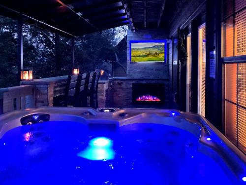 a jacuzzi tub in a backyard with a fireplace at Majestic Poolside Lookout in Pigeon Forge