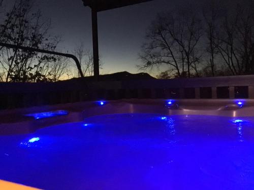a hot tub lit up with blue lights at night at Majestic Poolside Lookout in Pigeon Forge