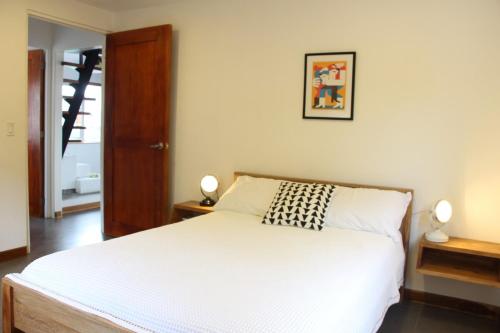a bedroom with a white bed and two lamps at CASA DINIS - Loft - With View Bahia de Portobelo in Portobelo
