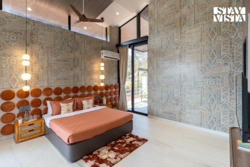 a bedroom with a bed and a wall with patterns at StayVista at The Nest at Canary Farms - Pool, Lawn in Āmbavna