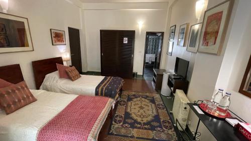 a hotel room with two beds and a television at Zaza Stay in New Delhi