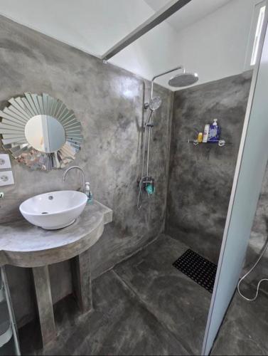 a bathroom with a sink and a shower with a mirror at BUDDY Villas - LOMBOK in Pawenang