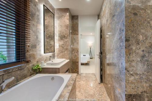 a bathroom with a tub and a sink at Ocean View Luxury Retreat - Private Villa by Nest Group in Nha Trang