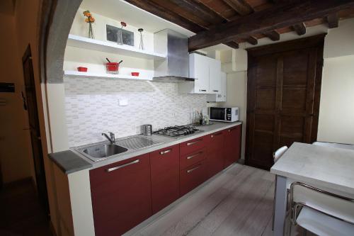 a kitchen with red cabinets and a sink at Visit Florentia Apartment in Florence