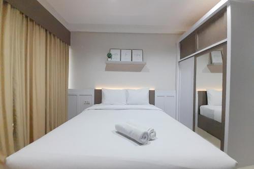 Beran-kidulCozy Studio Room at Patraland Amarta Apartment By Travelio的卧室配有一张白色大床,上面有毛巾