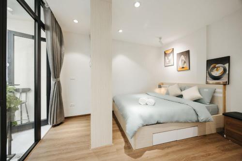 a bedroom with a bed with white walls at 4Brs 20mToHoanKiemLake Central Private OldQuarter in Hanoi
