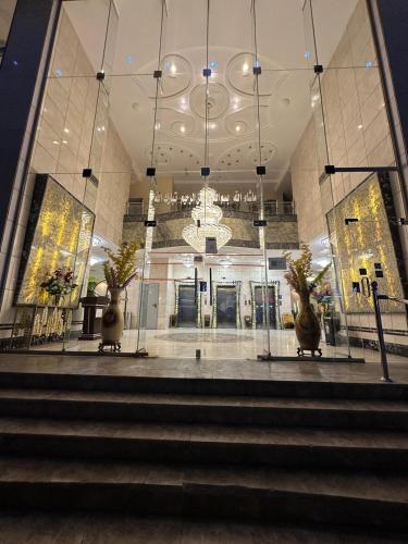 a lobby with stairs and a chandelier in a building at فندق نجمة ذاخر توصيل مجاني للحرم - Zakher Star Hotel Free Shuttle Service in Makkah