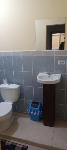 a bathroom with a toilet and a sink and a mirror at LA DOLCE VITA FRANCOPHONE in Estelí