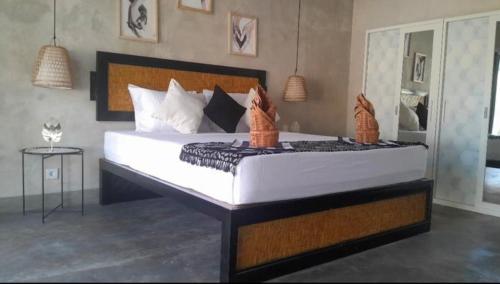 a bedroom with a large bed with white sheets at BUDDY Villas - LOMBOK in Pawenang