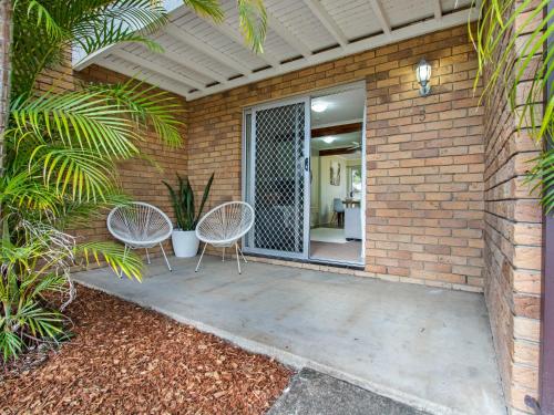 PialbaにあるRelaxing Townhouse Steps from the Beachのパティオ(椅子2脚付)、窓付きのドア