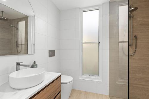 a white bathroom with a sink and a shower at Ellenvale in Queenscliff