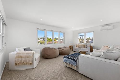 a white living room with white furniture and windows at Ellenvale in Queenscliff