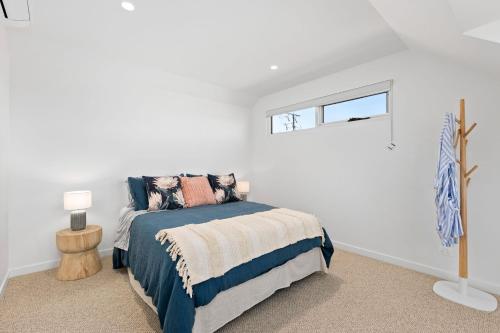 a white bedroom with a bed and a window at Ellenvale in Queenscliff