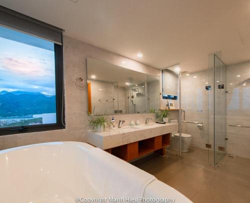 a bathroom with a tub and a shower and a large window at Ocean View Luxury Retreat - Private Villa by Nest Group in Nha Trang