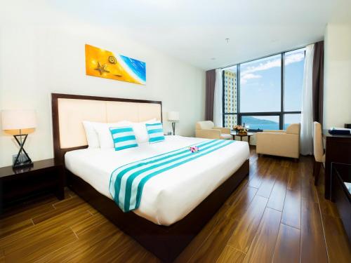 a bedroom with a large bed and a living room at Avatar Danang Hotel in Da Nang