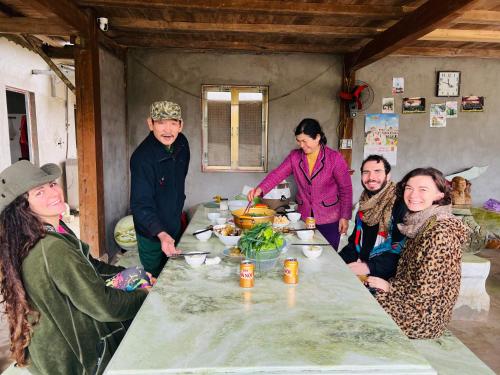 a group of people sitting around a table with food at Fish Farm Homestay in Yên Bái