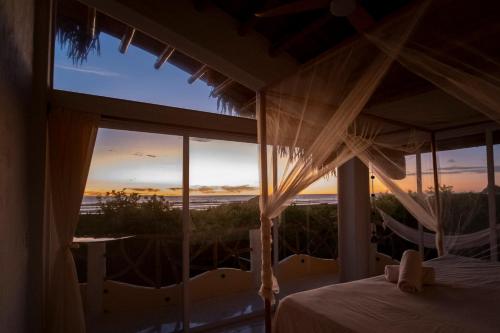 a bedroom with a bed and a view of the ocean at Tierra Munay in Las Tunas