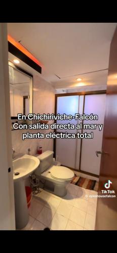 a bathroom with a toilet and a sink at residencias lalamar in Chichiriviche