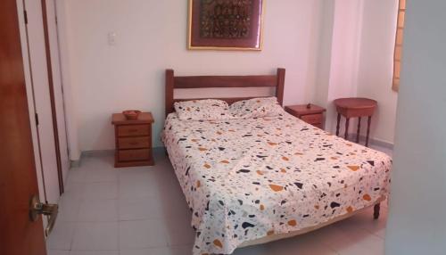a bedroom with a bed with a comforter on it at residencias lalamar in Chichiriviche