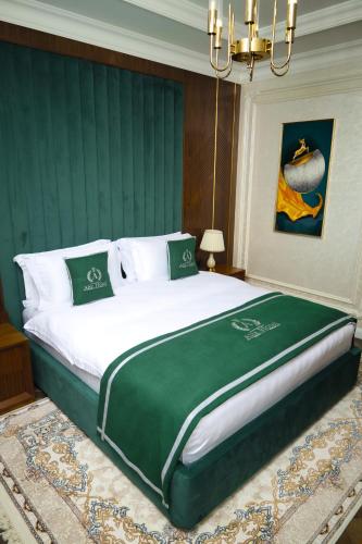 a bedroom with a large bed with a green headboard at Aliz Boulevard Hotel in Samarkand